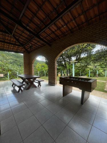 a patio with two ping pong tables and two benches at Casa na serra de mulungu in Mulungu