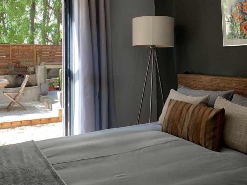 a bedroom with a bed with a lamp next to a window at Julu Guest House in Riebeek-Kasteel