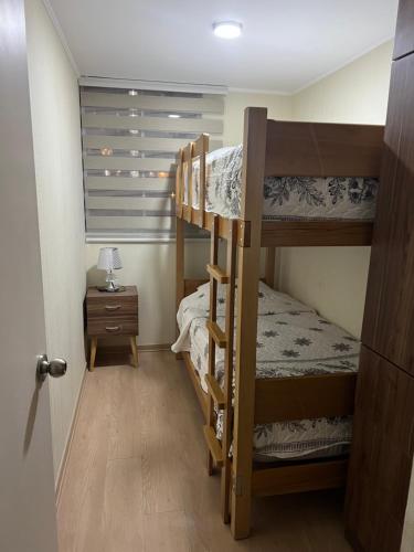um quarto com 2 beliches e uma mesa em Moderno Apartamento en Condominio Alto Venezuela em Lima