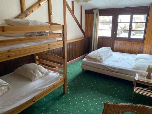1 dormitorio con 2 literas y ventana en Joyeux Flocon - Spacieux chalet en Les Contamines-Montjoie