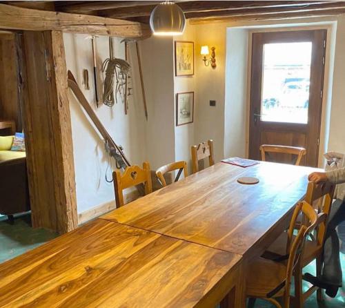 una gran mesa de madera en una habitación con sillas en Joyeux Flocon - Spacieux chalet en Les Contamines-Montjoie