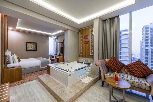 a hotel room with a bed and a bath tub at Crown Rose Al Sahafa Hotel in Riyadh