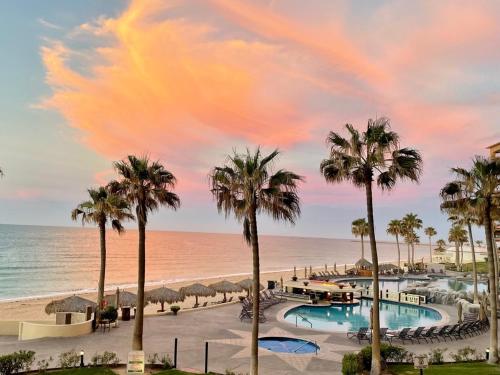 a view of a resort with palm trees and the beach at Sonoran Sea Resort BEACHFRONT Condo E203 in Puerto Peñasco