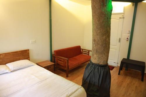 a room with a bed and a tree in it at SpiceBuds TreeHouse - Idukki in Ramakkalmedu