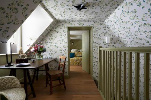 ein Esszimmer mit einem Tisch und einer Decke mit Blumen in der Unterkunft Hotel Endsleigh in Milton Abbot
