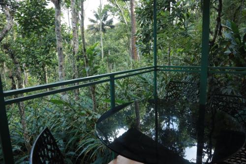 a glass table in the middle of a forest at SpiceBuds TreeHouse - Idukki in Ramakkalmedu
