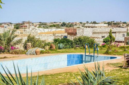 una piscina en un patio con una ciudad de fondo en Sand Rose Bahriya Hotel en Bawati