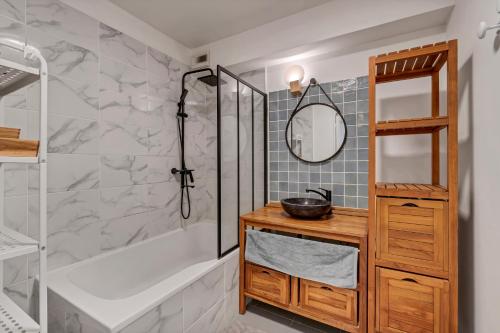 y baño con ducha, bañera y lavamanos. en Room in Appartment with seaview, en Marsella