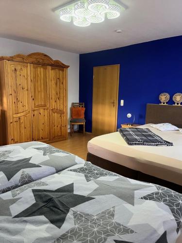 a bedroom with two beds and a blue wall at Ferienwohnungen Wotan in Thale