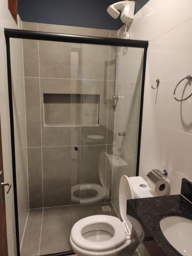 uma casa de banho com um chuveiro, um WC e um lavatório. em Vitória Suítes - Vila de São Jorge em São Jorge