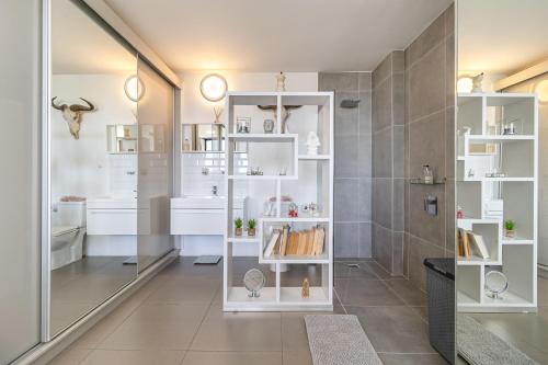 een badkamer met witte planken en een douche bij Cape Town Skyroof apartment LOADSHED PROOF Ocean Views in Kaapstad