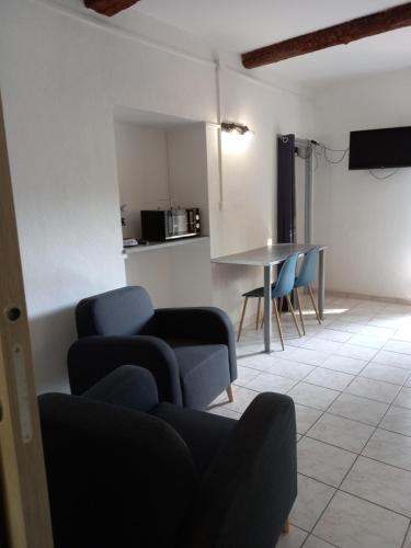 a living room with blue chairs and a table at Chambres d'hôtes Domaine de Pélissols in Bédarieux