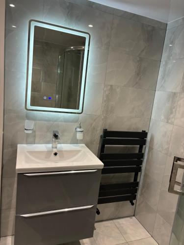a bathroom with a sink and a mirror at Exquisite 2 Bedroom Fully Furnished Annex in Bradenham