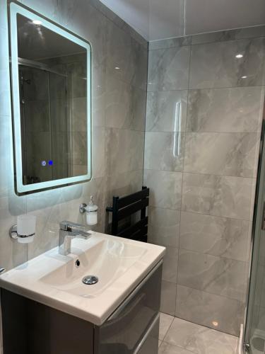 a white bathroom with a sink and a shower at Exquisite 2 Bedroom Fully Furnished Annex in Bradenham