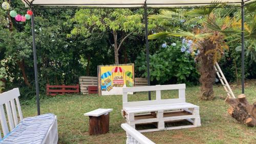 a white bench and a sign under a tent at Cygnus Hostel in Valdivia