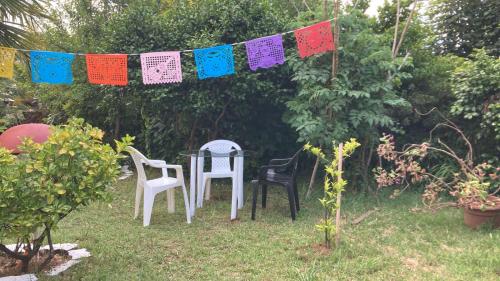 a table and chairs in a garden with a banner at Cygnus Hostel in Valdivia