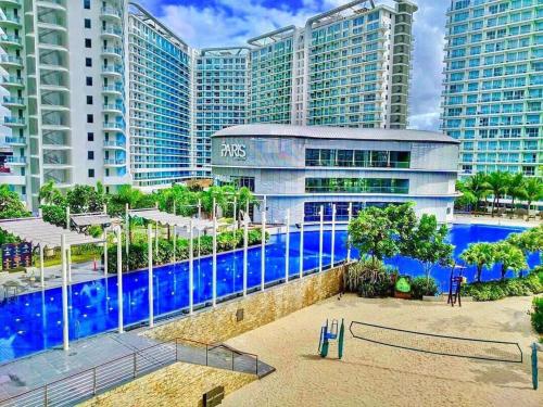 a pool in front of a building with tall buildings at Azure Urban Resort Staycation By Owner Only in Manila