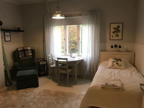 een slaapkamer met een bed, een tafel en een raam bij Viehättävä yksiö merellisessä Kotkassa. in Kotka