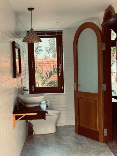 a bathroom with a sink and a toilet and a window at Soleil de An Bang Villa in An Bàn (2)