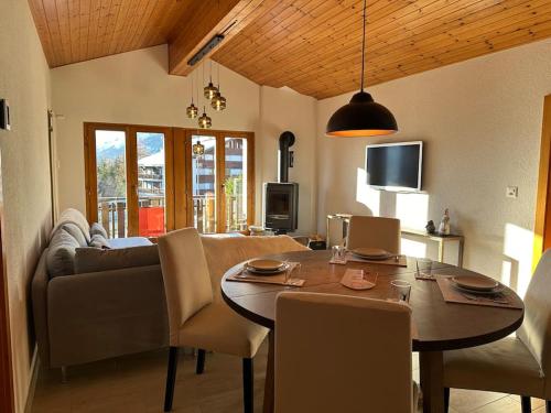 a living room with a table and a couch at APPARTEMENT DE CHARME EN ATTIQUE dans UN PETIT CHALET in Crans-Montana
