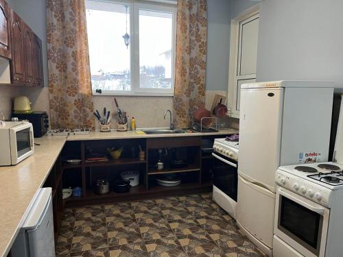 a kitchen with a white refrigerator and a sink at Atanasovata Kashta in Govedartsi