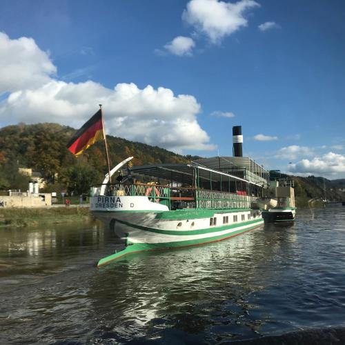 a boat with a flag is on the water at Gasthof zur Hoffnung in Hinterhermsdorf
