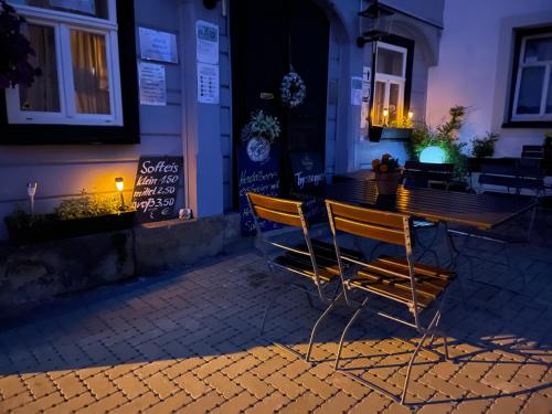 a bench sitting in front of a building at night at Gasthof zur Hoffnung in Hinterhermsdorf