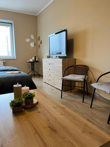 a bedroom with a tv and a bed and a chair at Gdynia Pokoje Blisko Morza i Centrum in Gdynia