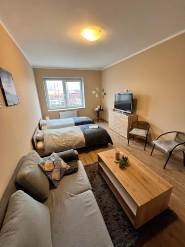 - un salon avec deux lits et un canapé dans l'établissement Gdynia Pokoje Blisko Morza i Centrum, à Gdynia