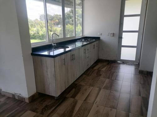 uma cozinha com um lavatório e algumas janelas em Casa Club Caminos del Peñón em El Brasil