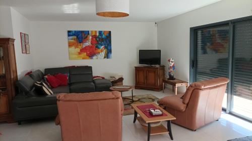 un salon avec un canapé, des chaises et une télévision dans l'établissement Villa Chez Louise, à Vaux-sur-Mer