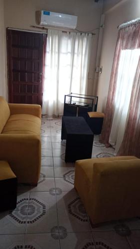 a living room with yellow couches and windows at Alvar Nuñez in Puerto Iguazú