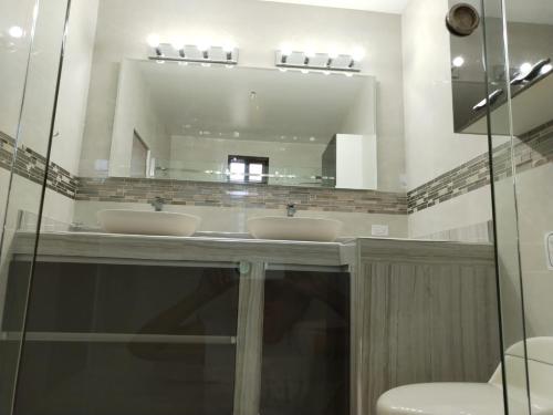 uma casa de banho com 2 lavatórios e um espelho grande em CORONADO, LAS BRISAS em Playa Coronado