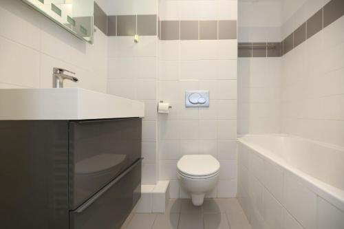 y baño con aseo, lavabo y bañera. en Appartement service - Vue sur le Musée - Paris 5, en París