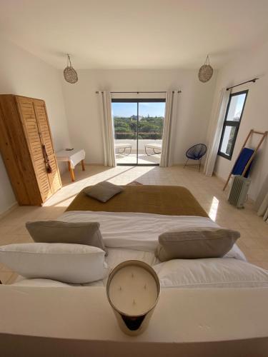 a large bedroom with two beds and a balcony at Dar Essa a Essaouira, personnel inclus, piscine chauffée in Essaouira