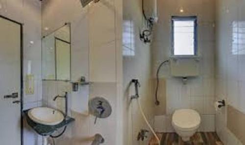 uma casa de banho com um lavatório, um WC e um lavatório. em HOTEL ORBITINN MALAD em Mumbai