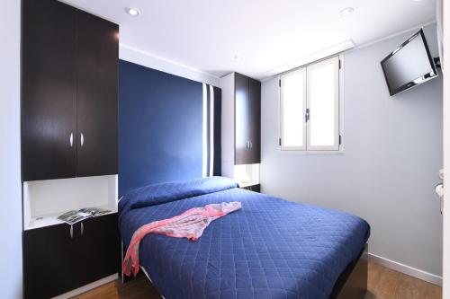 um quarto com uma cama azul e uma janela em La stanza sul Porto di Amalfi camera piccina piccina con bagno privato em Amalfi