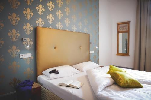 a bed with two pillows and a book on it at Hotel Tannhäuser in Heidelberg