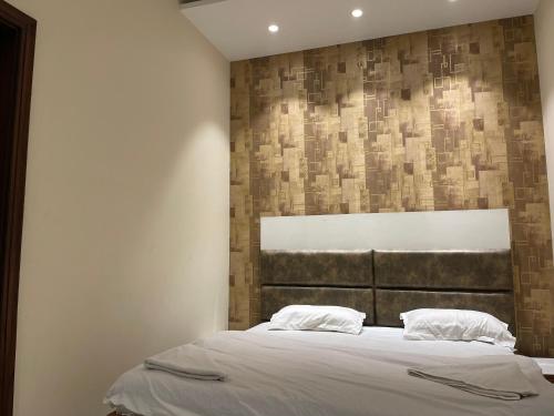 een slaapkamer met een bed met een bakstenen muur bij Hotel Paradise Dream in Ludhiana