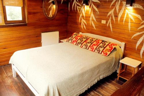 a bedroom with a bed in a room with wooden walls at Cabañas Recanto in Mar del Plata