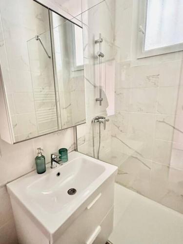 y baño blanco con lavabo y ducha. en Petit studio cosy - Proche gare / téléphérique, en Toulon