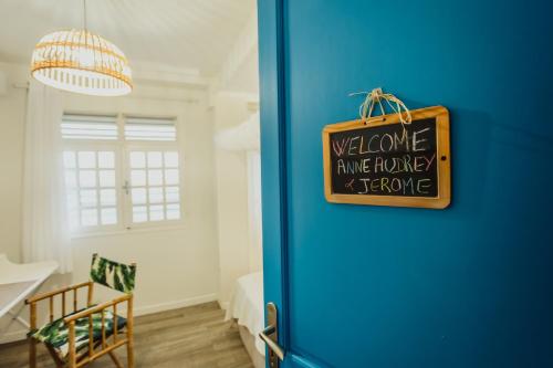 a blue door with a welcome arrive journey sign on it at Havre de paix à Fort de France in Fort-de-France