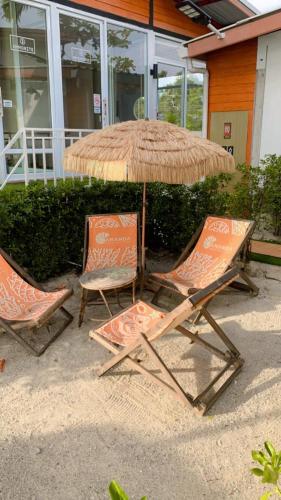 two chairs and an umbrella on the beach at Amanda อามันดา in Ban Pak Ba Ra