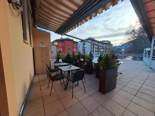 un patio con tavoli e sedie su un balcone di Appartamento grande Al Ponte. Situato vicino all'ospedale, al parco e al centro città a Trento