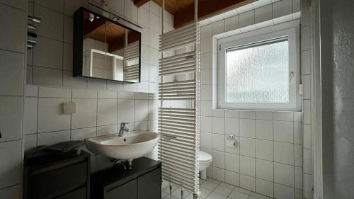 ein Badezimmer mit Waschbecken und Toilette und einem Fenster in der Unterkunft Ferienwohnung Doberschau, 3 Minuten zu Bautzen in Doberschau