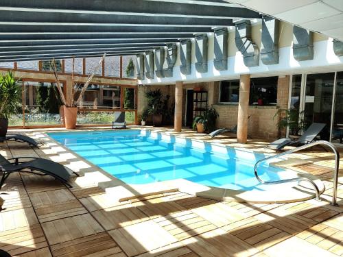 a large swimming pool in a building with chairs at La Pradella appartement 4/6 places in Bolquere Pyrenees 2000