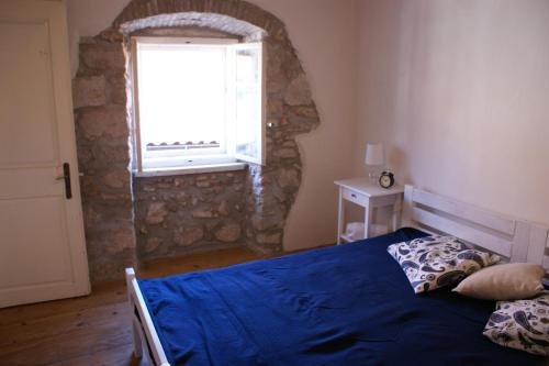 a bedroom with a blue bed and a window at Apartment Mila Krk in Krk