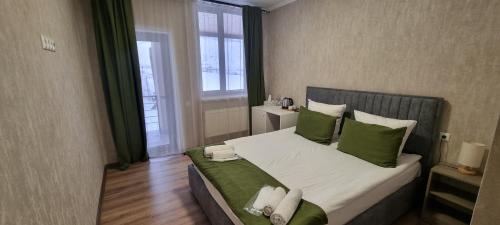 1 dormitorio con 1 cama grande con almohadas verdes en Tsaghkunk Chef house, en Sevan