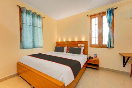 テーニにあるSuper Collection O Velu Residencyのベッドルーム1室(青いカーテン付きの大型ベッド1台付)