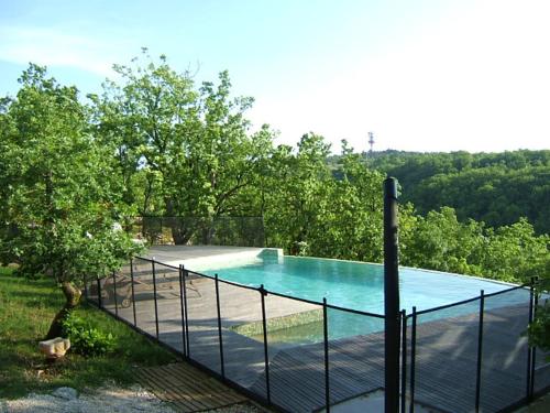 une piscine entourée d'une clôture dans l'établissement Gîte des Camazets avec piscine, à Trespoux-Rassiels